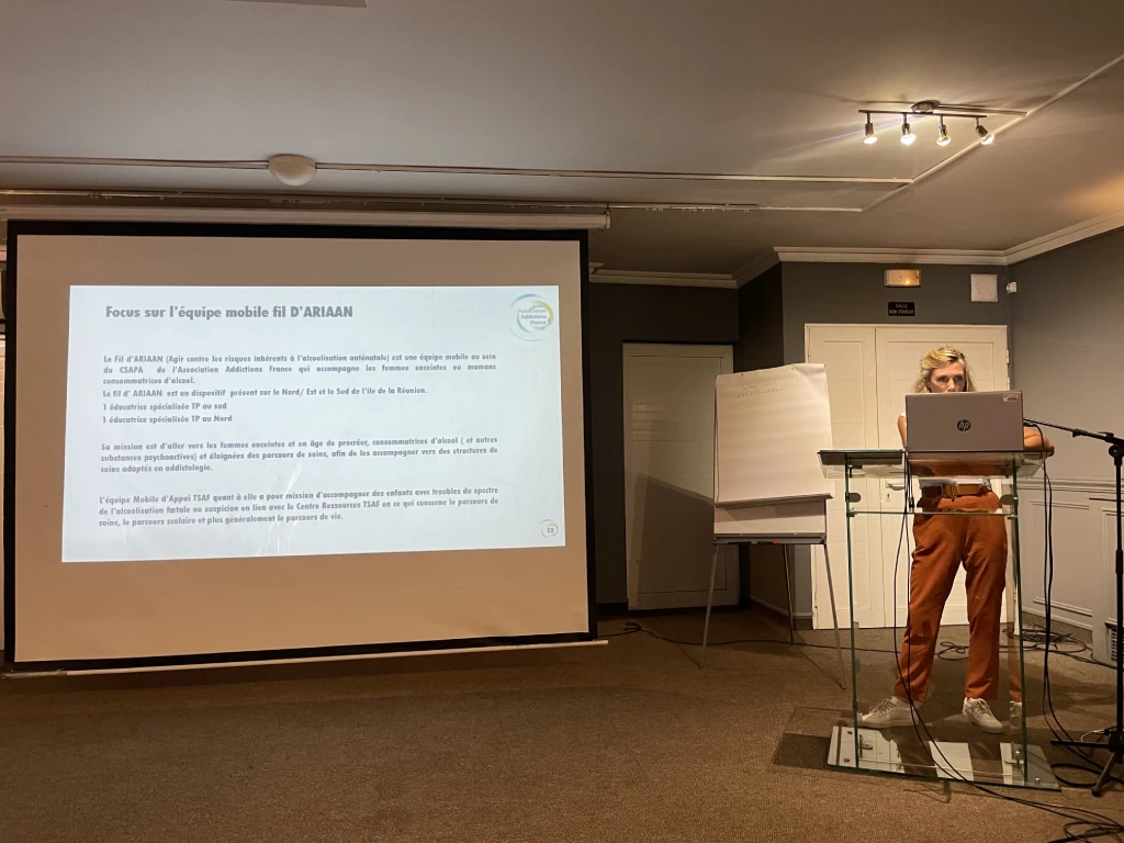 Conférencière s'exprimant devant une diapositive