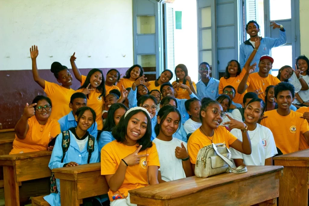 Élèves souriants posant dans leur salle