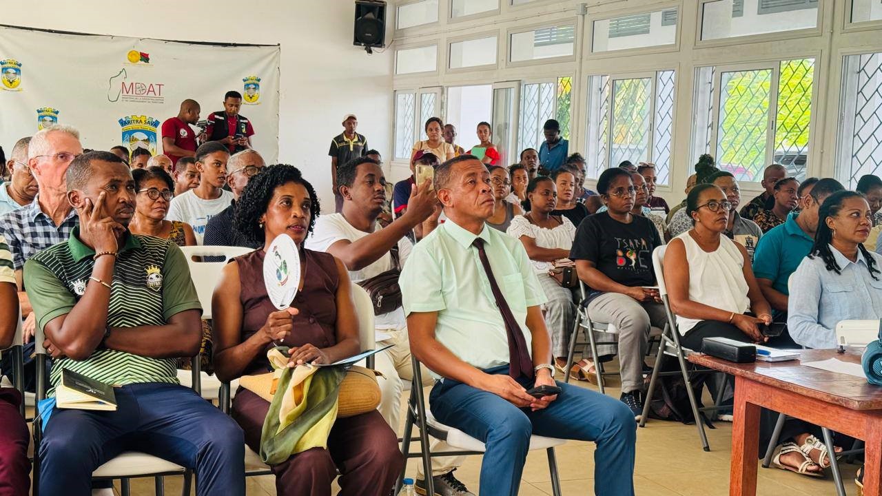 Assemblée attentive écoutant la présentation de sensibilisation