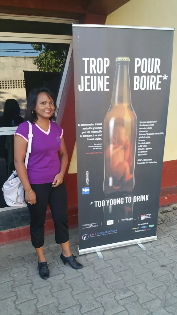 Une participante posant à côté de l'affiche